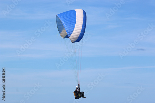 Paraglider flying blue wing