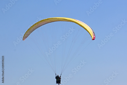 Tandem Paraglider flying yellow wing