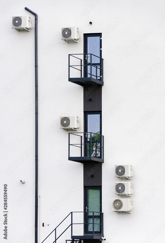 Abstract architecture picture with doors, balconies, some air conditioning and cctv security camera on gray industrial wall. Abstract architecture picture with doors, balconies, some air conditioning and cctv security camera on gray industrial wall.