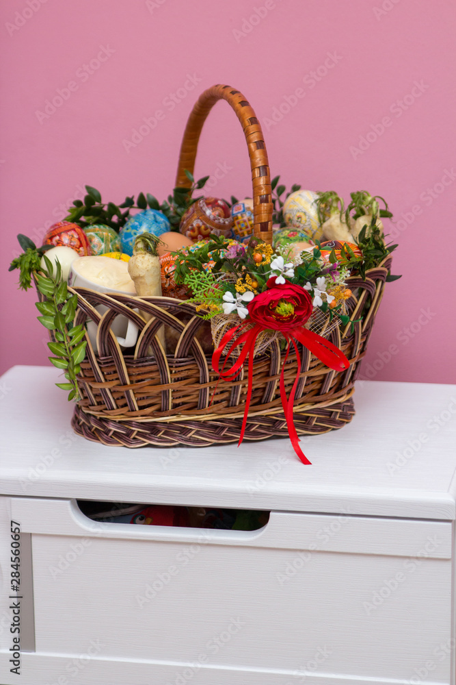 Easter basket on the bedside table,on a white bedside table there is an Easter basket with a Easter cake and a sausage and eggs