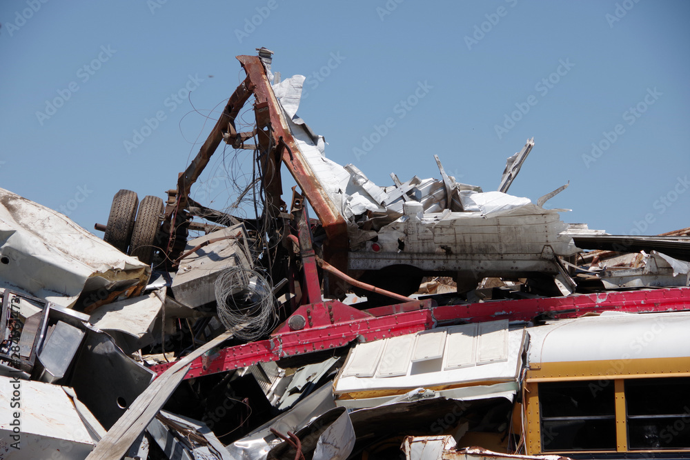 Fototapeta premium Pile of scrapped vehicles and other materials with blue sky above