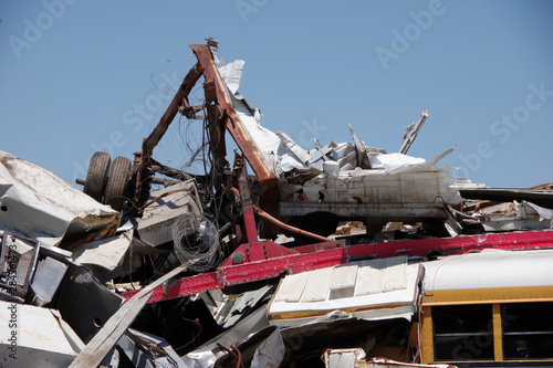 Pile of scrapped vehicles and other materials with blue sky above