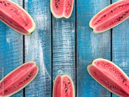Large pieces of ripe watermelon on a blue wooden background. Copyspace. Summer.