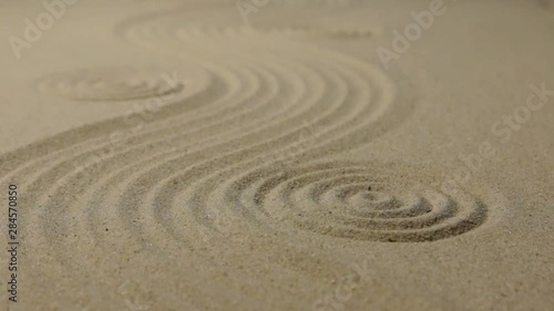 Refocusing the focus from the front circle to the far circle. Zen garden wit simple flowing waves and concentric circles.