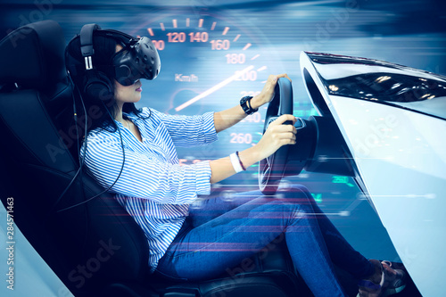 Woman driving a simulator car with fast motion photo