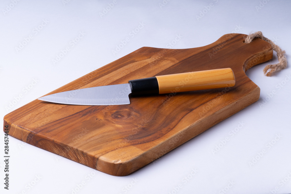 Olive wooden cutting Board with japanese knife on white background.