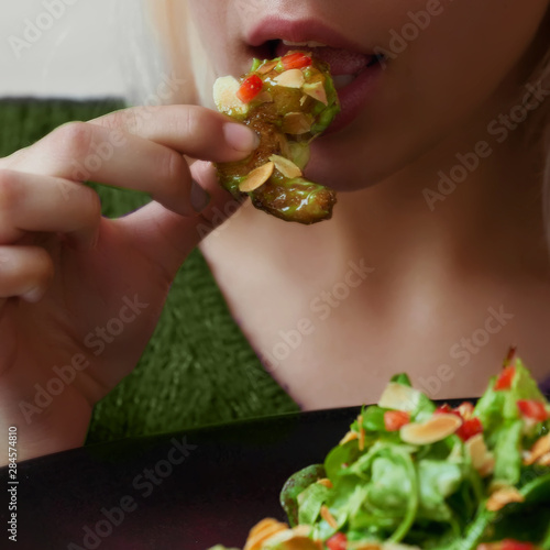 Girl eating shrimp close-up lips ajar mouth holding a plate