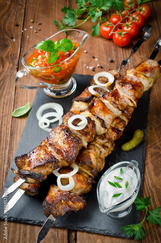 Pork skewers with onions on a wooden table