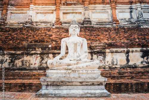 Buddha statue on old wall background in an ancient city in Thailand. Medieval Buddhist temple Wat Yai Chai Mongkhon (Wat Yai Chaimongkol) in Ayutthaya, a day trip travel destination from Bangkok. photo