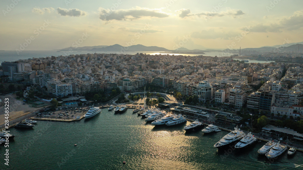 Aerial drone photo of iconic round port of and Marina of Zea or Pasa Limani at sunset with beautiful golden colours and cloudy clear sky, Piraeus, Attica, Greece