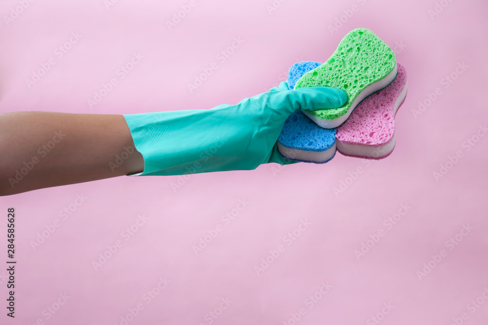 Hands of woman wearing gloves prepared to wash dishes with a sponge - obrazy, fototapety, plakaty 