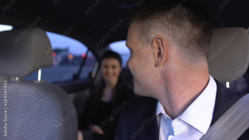 Handsome male in suit waiting female in auto and smiling, feeling affection Handsome male in suit waiting female in auto and smiling, feeling affection