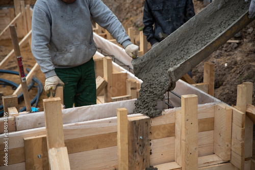 Workers pour concrete into the foundation