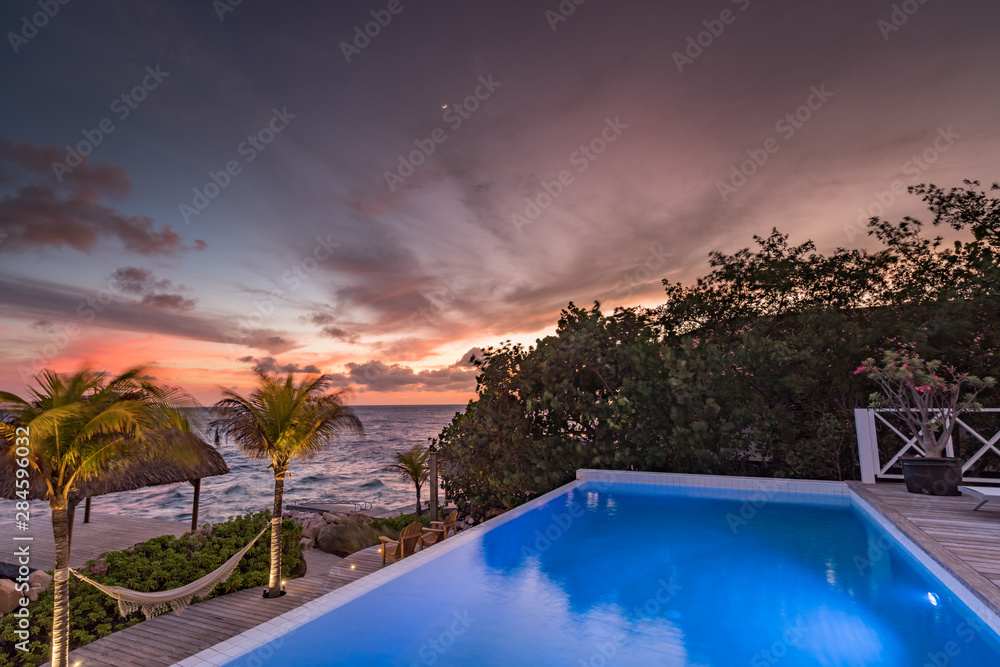 Sunset over the sea from a house and swimming pool