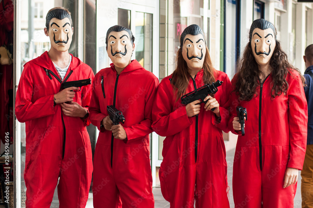group of fans of the serie tv "La casa de papel (paper house) on Netflix  standing in the street with costume and Salvador Dali mask and false shot  guns Photos | Adobe