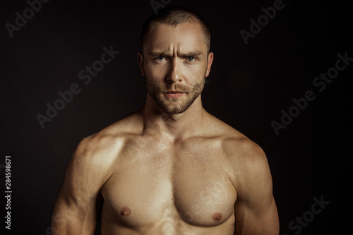 Handsome sport sexy stripped guy portrait for cosmetics and fitness drops on isolated black background © Oleh Phoenix