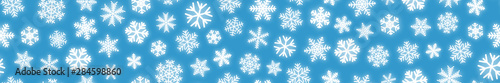 Christmas horizontal seamless banner of white snowflakes on light blue background