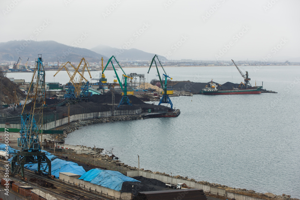 Coal terminal in the sea trading port of the sea city of Nakhodka. Coal collapse on the coast of a large city.