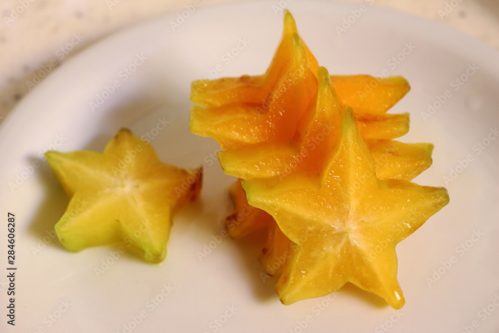 Fresh star fruit sliced, ready to be eaten. Sweet fruit in a white dish. It's an adorable fruit because of its shape Fresh star fruit sliced, ready to be eaten. Sweet fruit in a white dish. It's an adorable fruit because of its shape