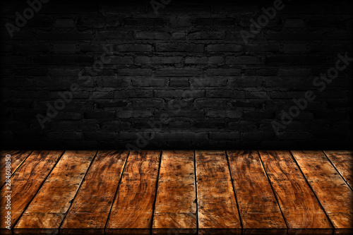 Empty wooden table isolated on black brick wall background