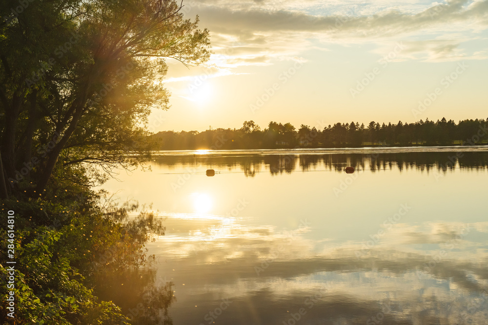 The orange light of a beautiful sunset is reflected in the eagle creek at Marinette,WI. The orange light of a beautiful sunset is reflected in the eagle creek at Marinette,WI.
