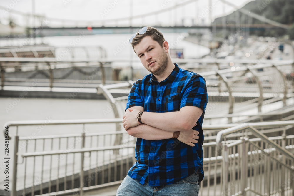Young man with seriously mood look at the view of city, plump people concept, one in big city life. Image of guy at downtown Young man with seriously mood look at the view of city, plump people concept, one in big city life. Image of guy at downtown