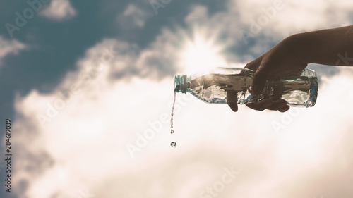 Pouring a clear plastic bottle of pure drinking water refreshing and splash on a heat wave background with a hungry and thirsty concept for good health.