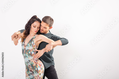 Young love couple dancing social danse kizomba or bachata over white background with copy space