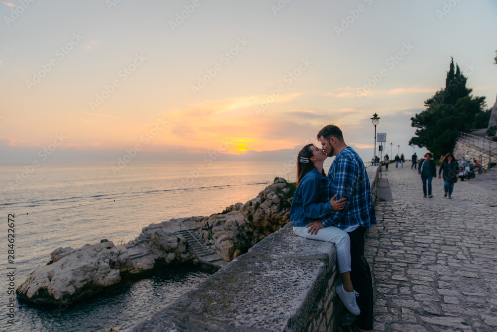 couple kissing with beautiful view of sunset over the sea