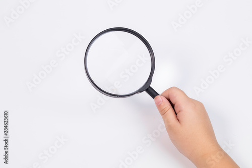 hand of little Asian boy age 5-7 years old with magnifying glass on white isolated background