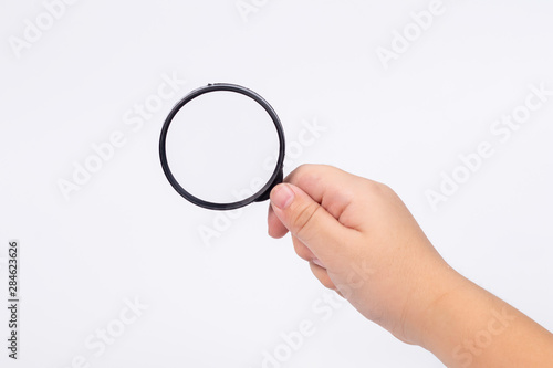 hand of little Asian boy age 5-7 years old with magnifying glass on white isolated background