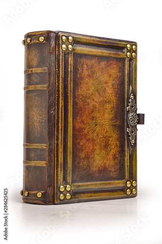 Aged large leather book with carved frame, metal pins in the corners, decoration as a door handle and gilded paper edges.