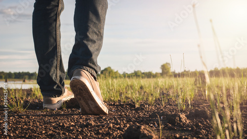 Close up image of Men jeans and sneaker walking at Countryside nature, Motivation and Travel concept