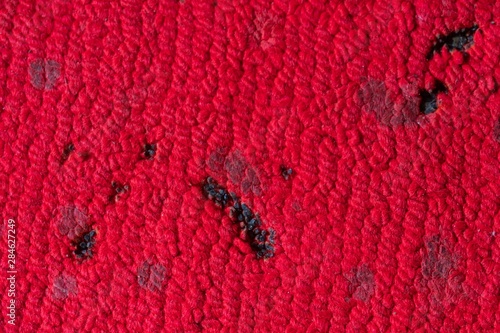 incense and candle burn marks on red carpet.