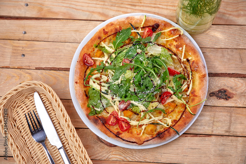 pizza with fresh vegetables on the wooden background