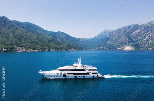View on the luxury yacht in Montenegro. Blue sea water background from air. Mountains and sea landscape. Summer seascape from air. Travel - image © biletskiyevgeniy.com