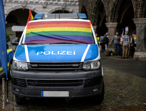 Foto police car with a wet rainbow flag on the windshield at the rainy christopher st