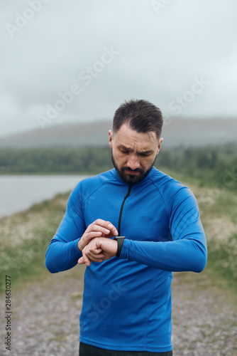 Handsome bearded man checking up his smart watch