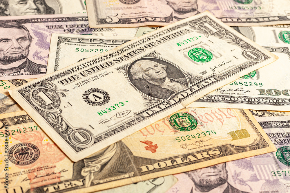USA dollar bills. A few dollars of varying nominal values. Texture of multiple US dollar banknotes. Background from paper money. Close-up of multiple American dollar banknotes. USA dollar bills. A few dollars of varying nominal values. Texture of multiple US dollar banknotes. Background from paper money. Close-up of multiple American dollar banknotes.