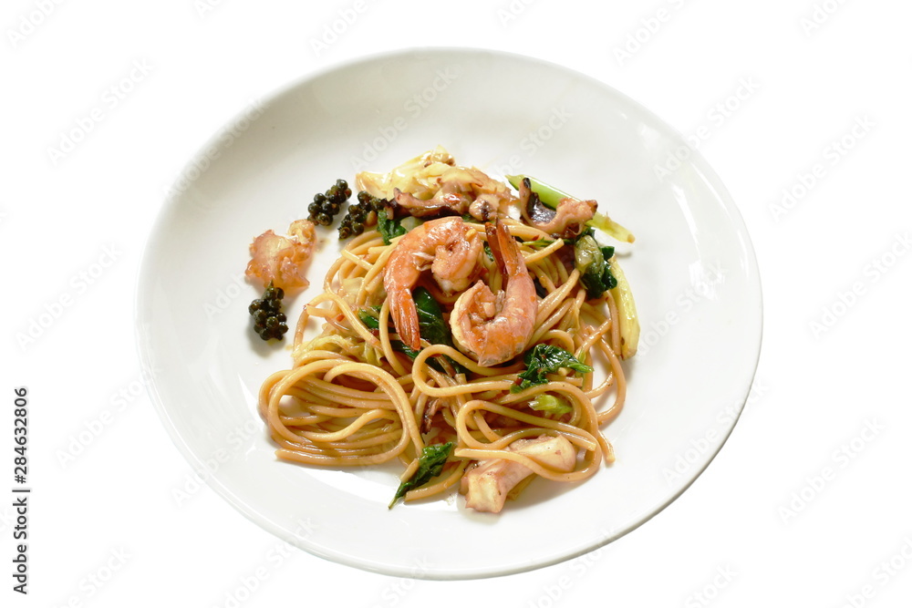 spicy stir fried spaghetti seafood with pepper and basil leaf on plate