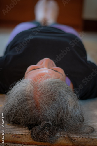 Senior Indian woman doing yoga at home early in the morning. India has been suffering with a surge of lifestyle diseases such as diabetes and hypertension. Only a few people are taking precautions .