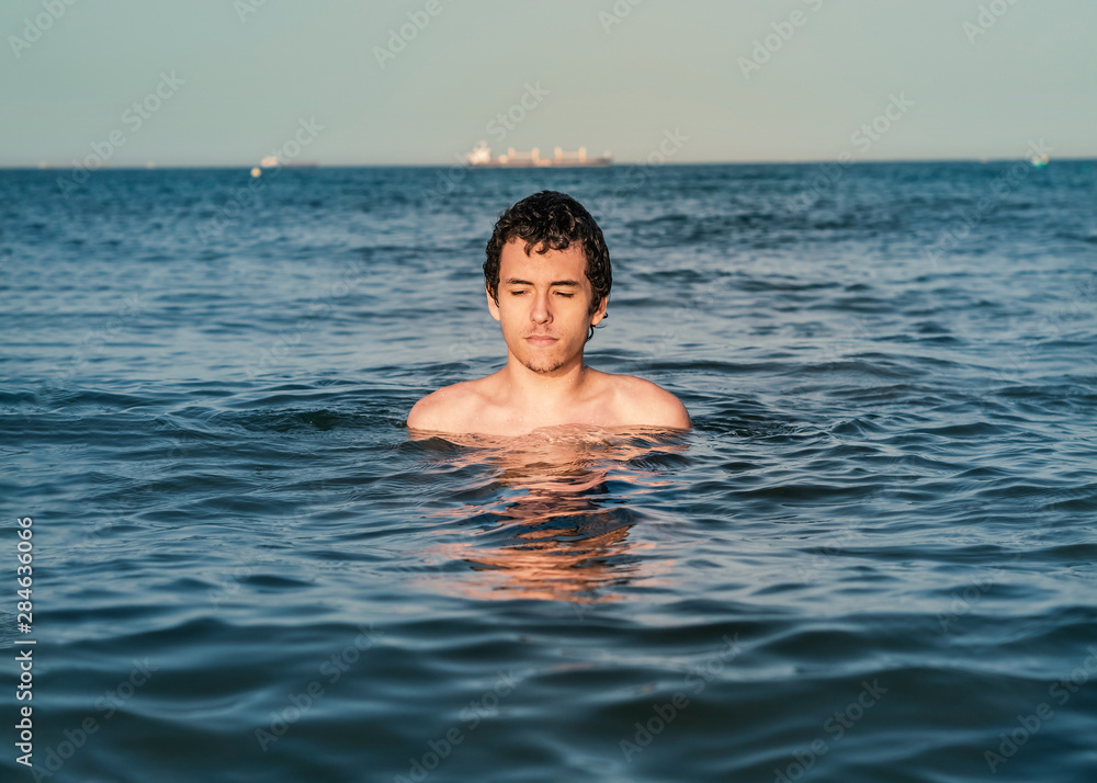 Young man relaxing and refreshing in the ocean