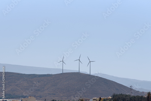 Wind turbines generating electricity with blue sky, renewable energy.