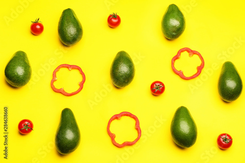Fresh avocados, pepper and tomato on color background