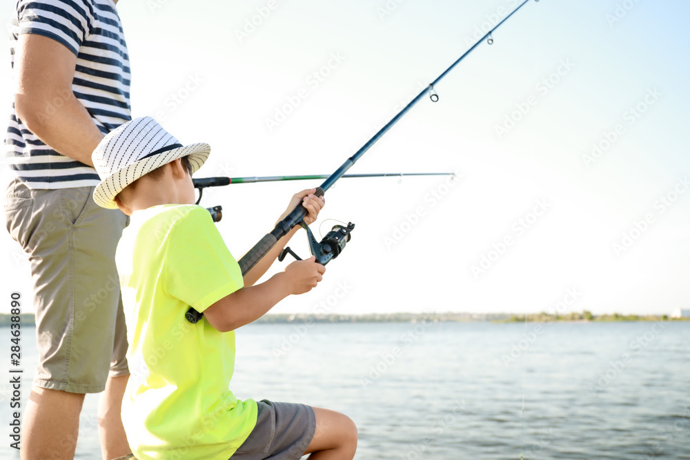 Father and son fishing together on river Father and son fishing together on river