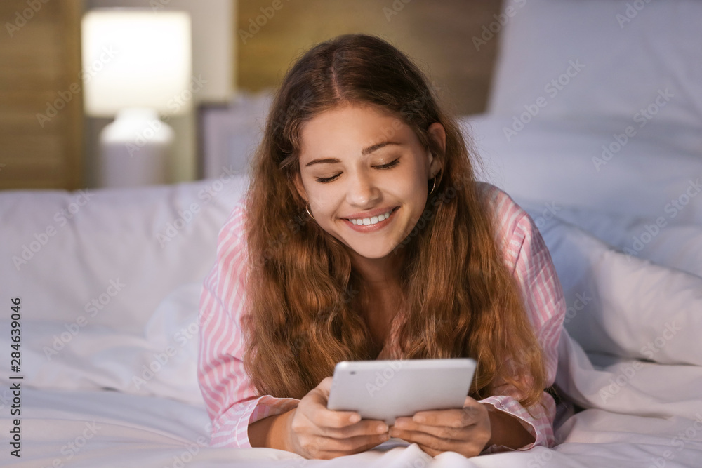 Teenage girl with tablet computer in bed at night Teenage girl with tablet computer in bed at night