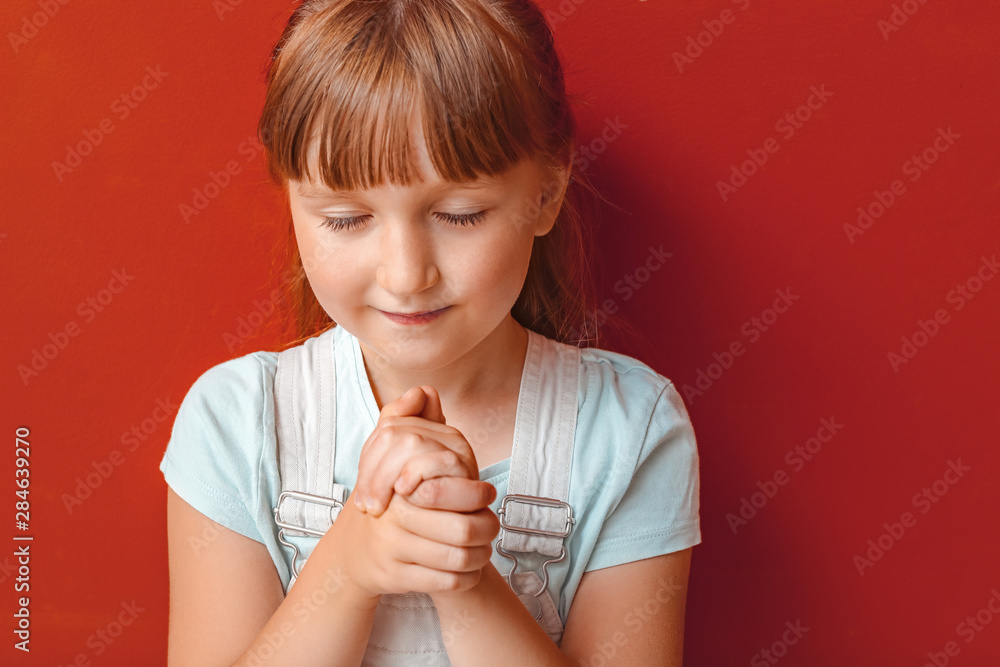 Little girl praying on color background Little girl praying on color background
