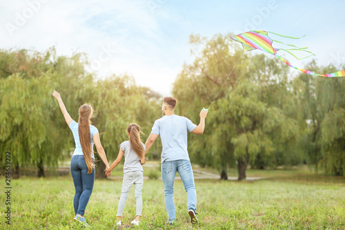 Happy family flying kite ou...
