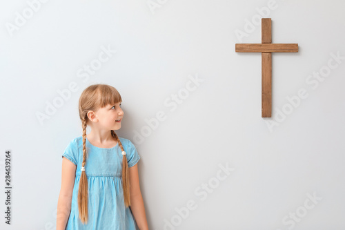 Little girl near light wall...