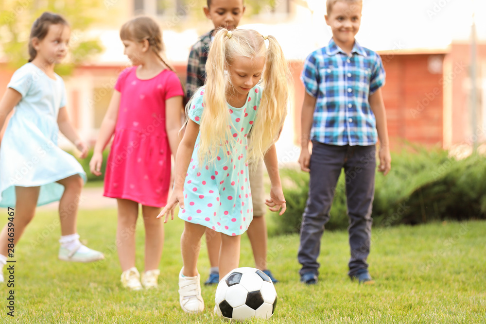 Cute little children playing football in park Cute little children playing football in park